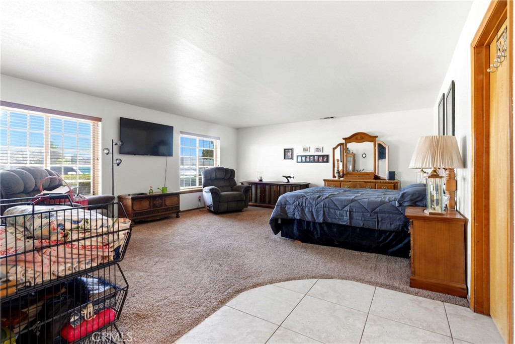 11468 Kiowa Road Apple Valley, CA 92308 - Photo 8 of 73 a bedroom with furniture and a flat screen tv