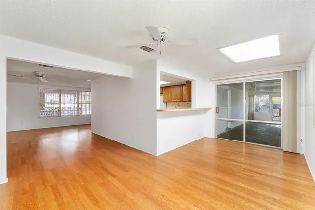 a view of a kitchen with wooden floor and a window