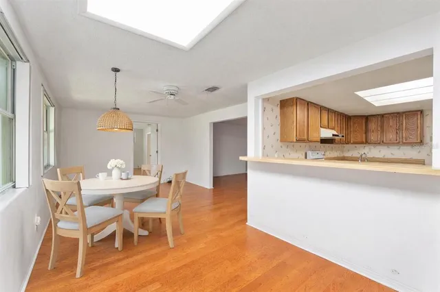 a kitchen with stainless steel appliances granite countertop wooden cabinets a sink and dishwasher a stove with wooden floor