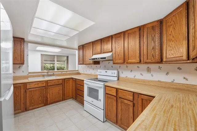 a view of an empty room with wooden floor and a ceiling fan