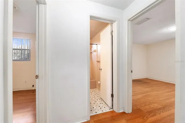 a view of a kitchen with white cabinets and wooden floor