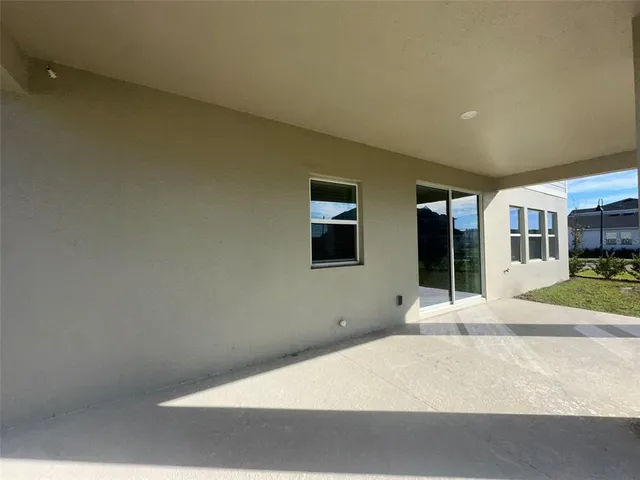 a view of a house with a big yard potted plants and large tree