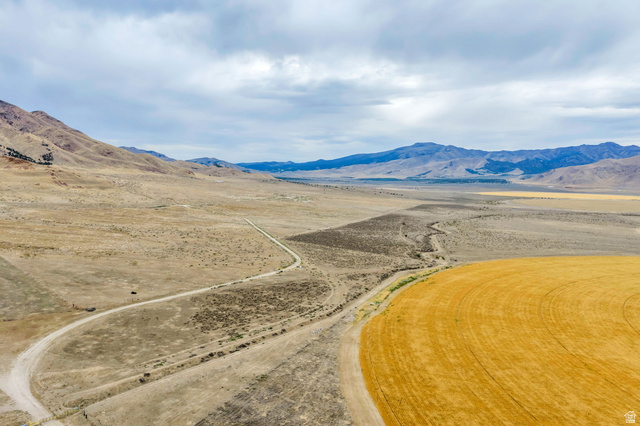 12800 South Crooked Cyn Road South Elberta, UT 84626 - Photo 5 of 48 Expansive open land featuring a cultivated circular field, extensive undeveloped terrain, and a winding dirt road
