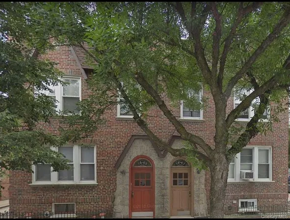 a front view of a house with a tree