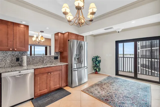 a kitchen with stainless steel appliances granite countertop a stove top oven a sink dishwasher and a cabinets with wooden floor