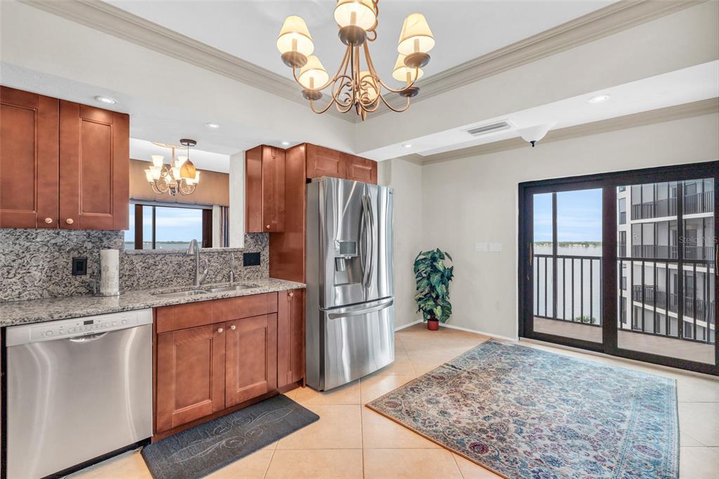 1920 Virginia Avenue, Unit 902 Fort Myers, FL 33901 - Photo 25 of 50 a kitchen with stainless steel appliances granite countertop a refrigerator a stove a sink dishwasher and wooden cabinets with wooden floor