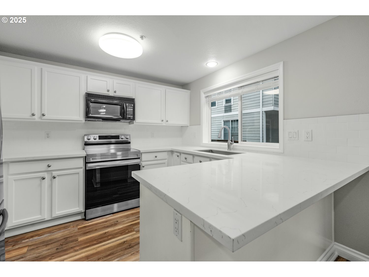 1244 Southwest 160th Avenue, Unit 104 Beaverton, OR 97006 - Photo 14 of 31 a kitchen with kitchen island a stove a sink and a refrigerator