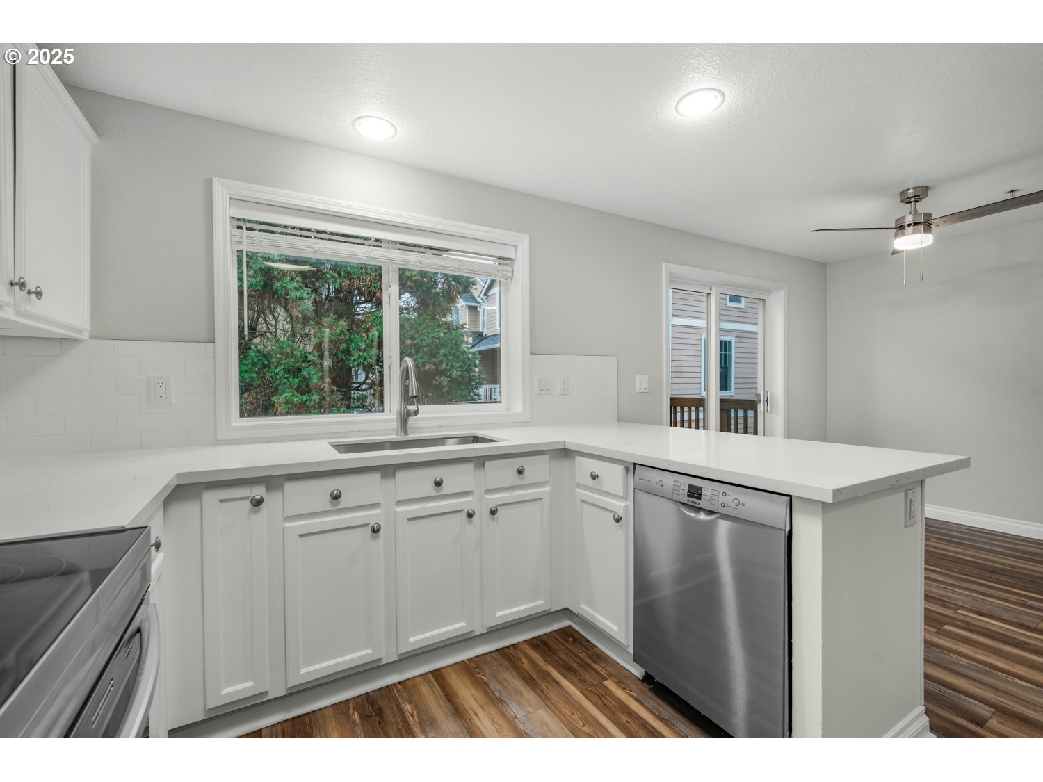 1244 Southwest 160th Avenue, Unit 104 Beaverton, OR 97006 - Photo 17 of 31 a kitchen with white cabinets a sink dishwasher and a stove with wooden floor