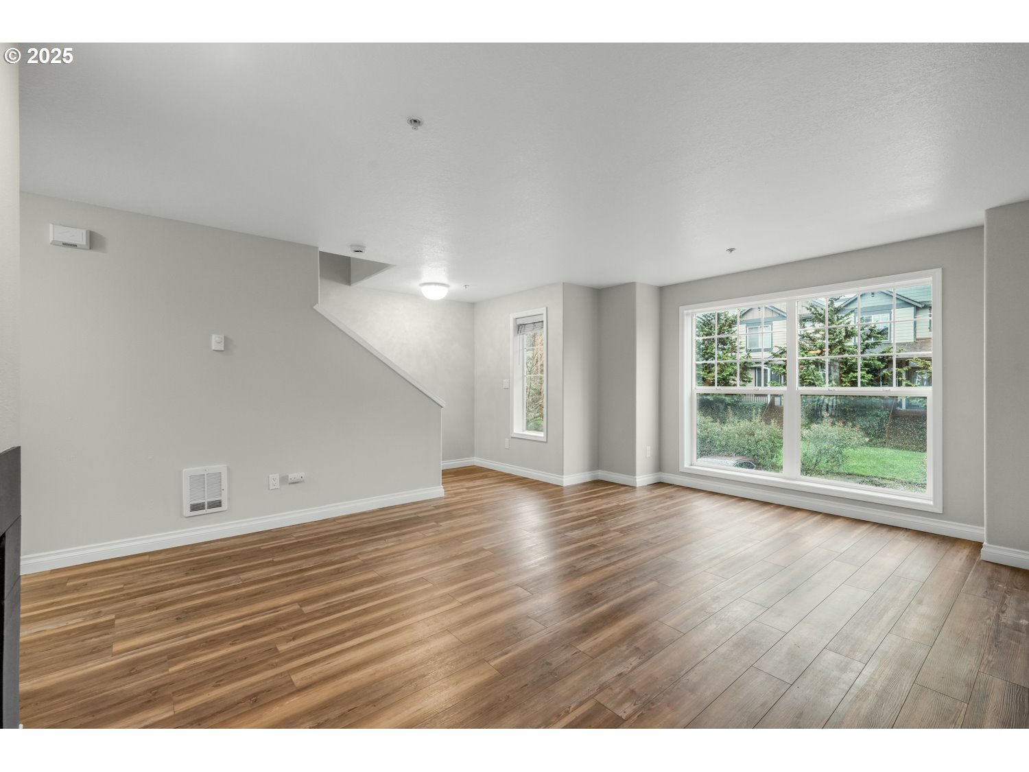 1244 Southwest 160th Avenue, Unit 104 Beaverton, OR 97006 - Photo 19 of 31 a view of an empty room with wooden floor and a window
