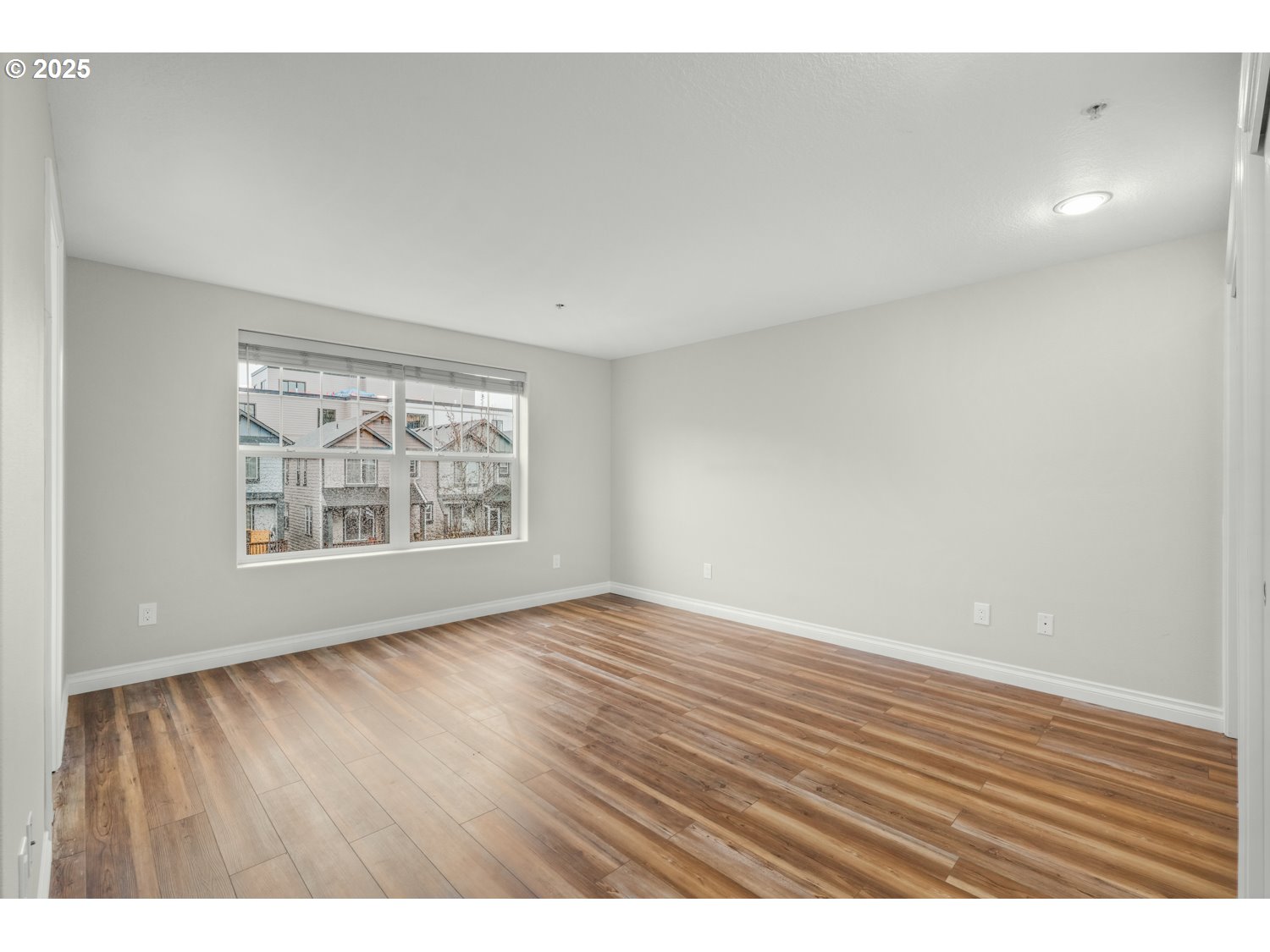 1244 Southwest 160th Avenue, Unit 104 Beaverton, OR 97006 - Photo 28 of 31 a view of an empty room with wooden floor and a window