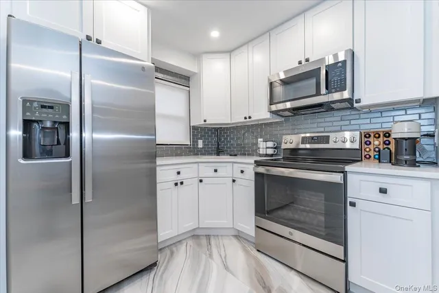 a kitchen with cabinets stainless steel appliances and a counter space