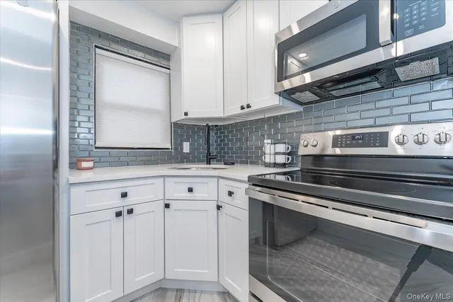 a kitchen with white cabinets and appliances