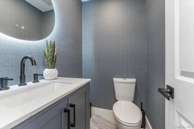 a bathroom with a toilet sink and mirror