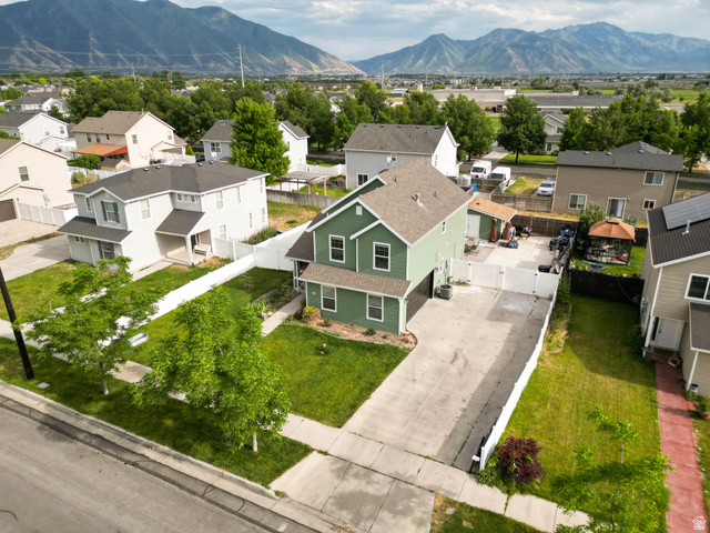 1443 West 250 North Springville, UT 84663 - Photo 6 of 23 Two-story residence with a light green exterior, an attached garage, and a concrete driveway