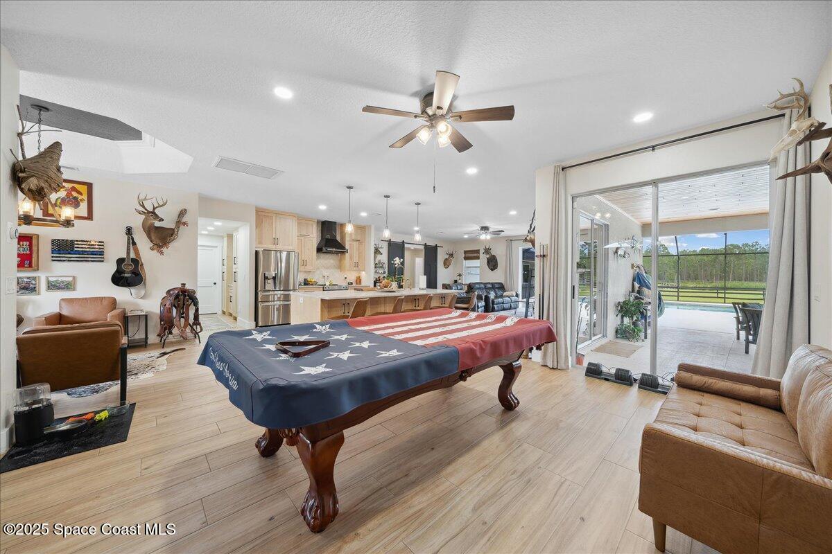 5005 Corey Road Grant Valkaria, FL 32950 - Photo 12 of 47 a living room with furniture a rug and a chandelier