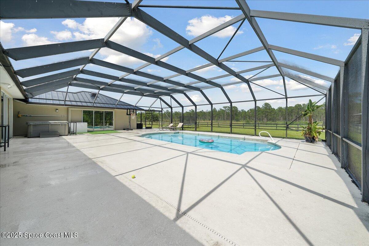 5005 Corey Road Grant Valkaria, FL 32950 - Photo 16 of 47 a view of a swimming pool with a porch