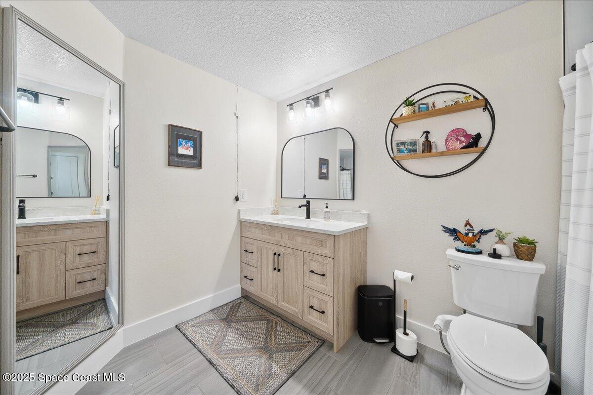 5005 Corey Road Grant Valkaria, FL 32950 - Photo 24 of 47 a bathroom with a toilet a sink and a mirror