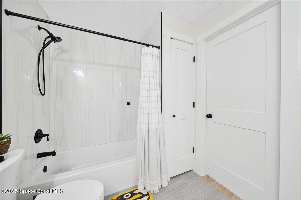 5005 Corey Road Grant Valkaria, FL 32950 - Photo 25 of 47 a bathroom with a shower a bath tub and a shower