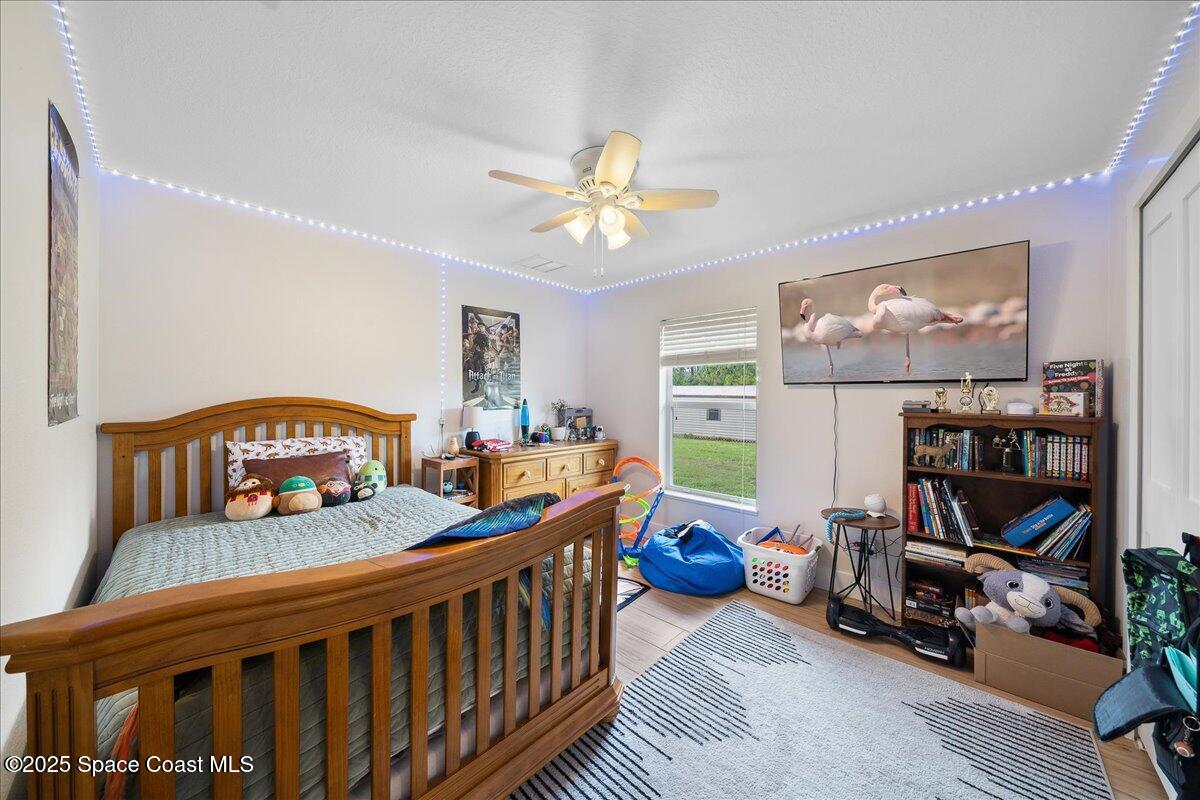 5005 Corey Road Grant Valkaria, FL 32950 - Photo 26 of 47 a bedroom with furniture a baby crib and a chandelier