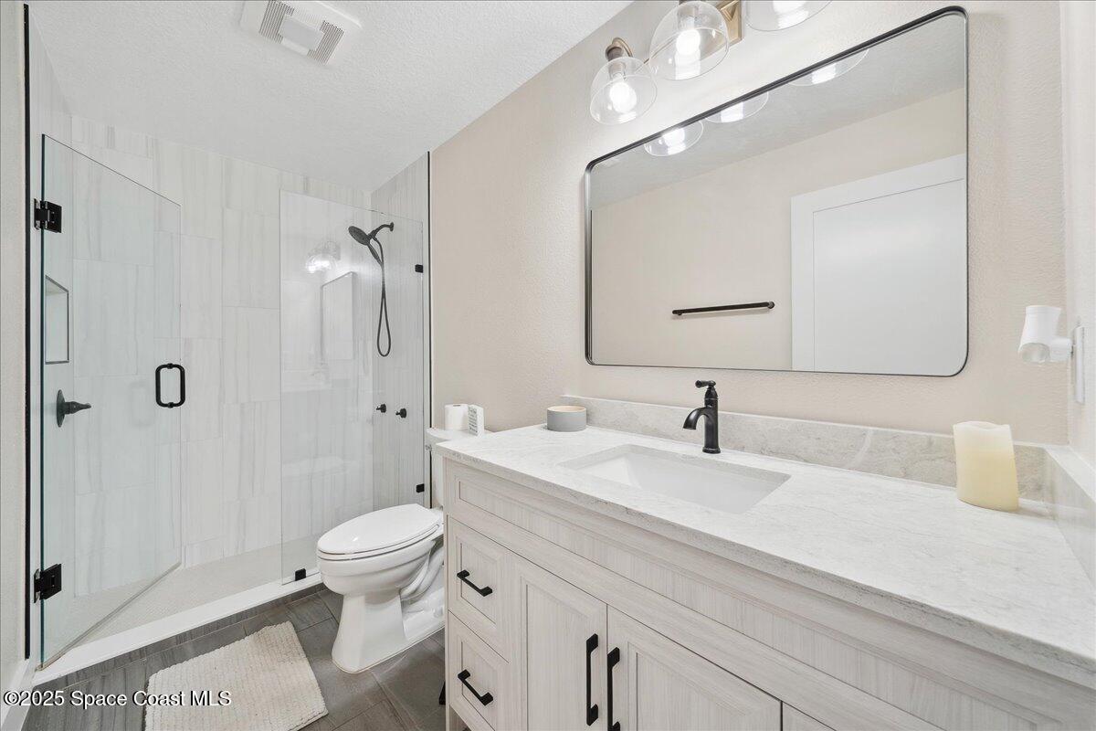5005 Corey Road Grant Valkaria, FL 32950 - Photo 27 of 47 a bathroom with a sink a toilet and shower