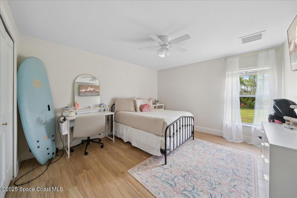 5005 Corey Road Grant Valkaria, FL 32950 - Photo 28 of 47 a room with a bed and wooden floor