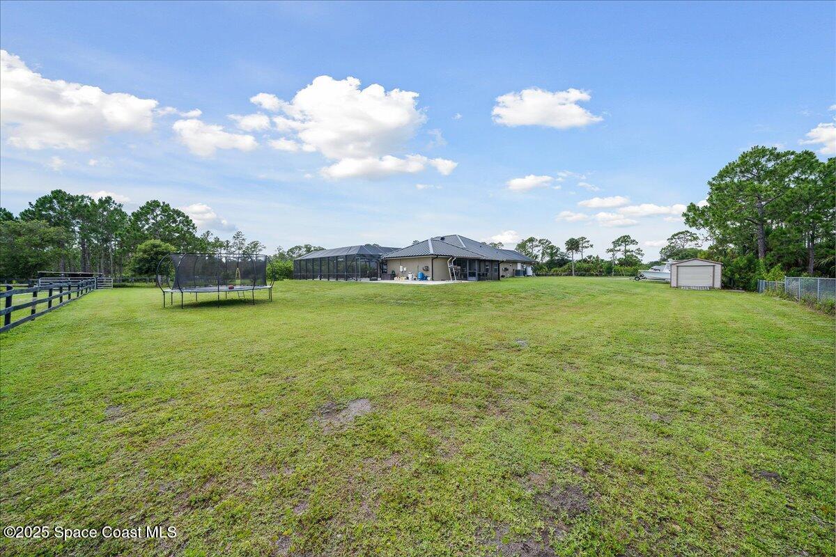 5005 Corey Road Grant Valkaria, FL 32950 - Photo 31 of 47 a view of a garden with a building in the background