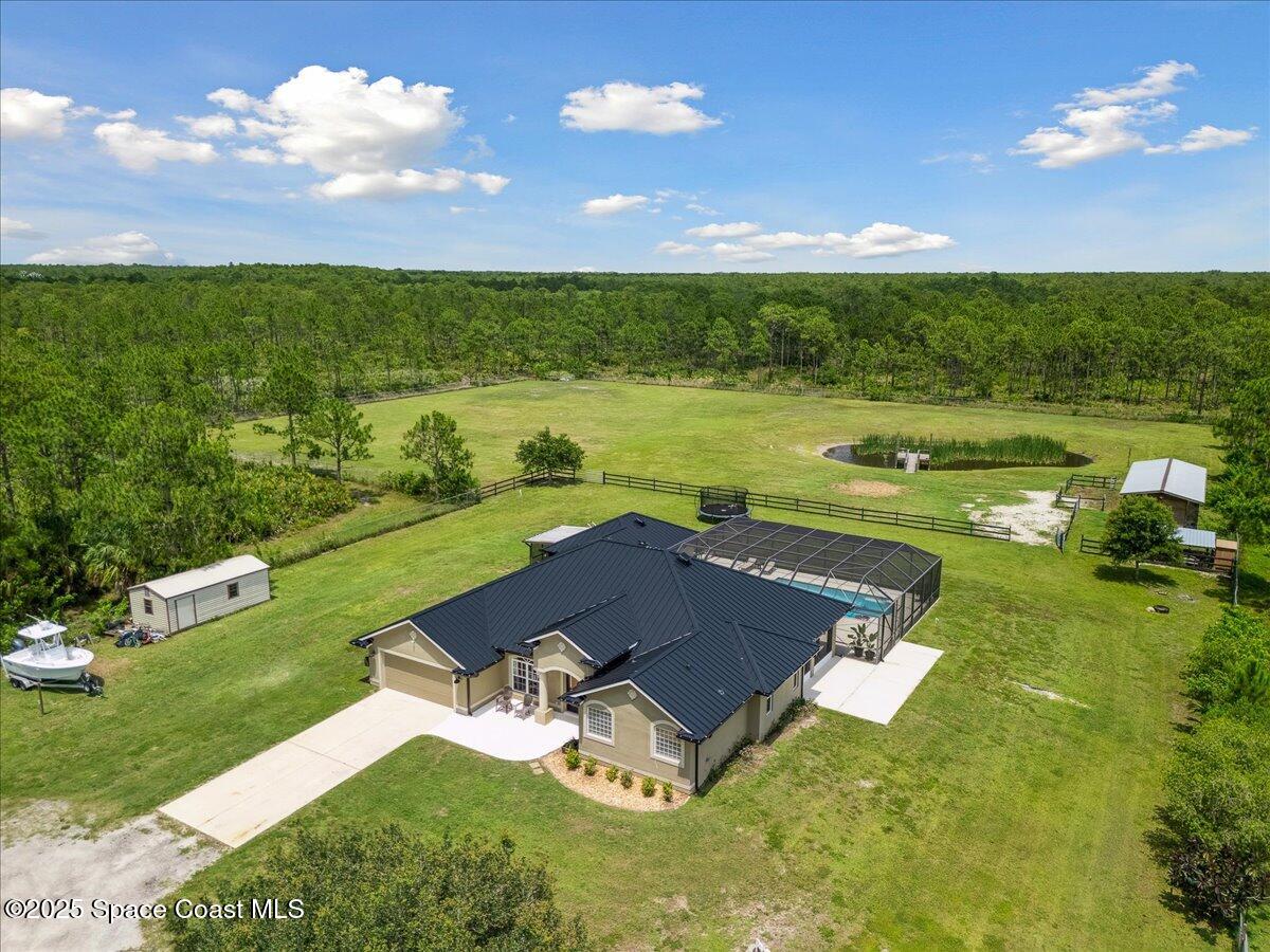 5005 Corey Road Grant Valkaria, FL 32950 - Photo 37 of 47 an aerial view of a house with a garden and swimming pool