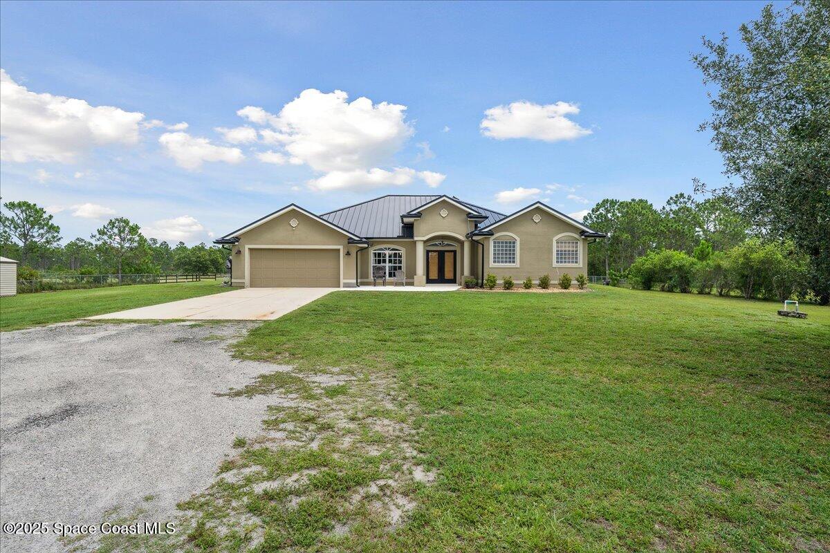 5005 Corey Road Grant Valkaria, FL 32950 - Photo 44 of 47 a view of a house with a big yard and large trees