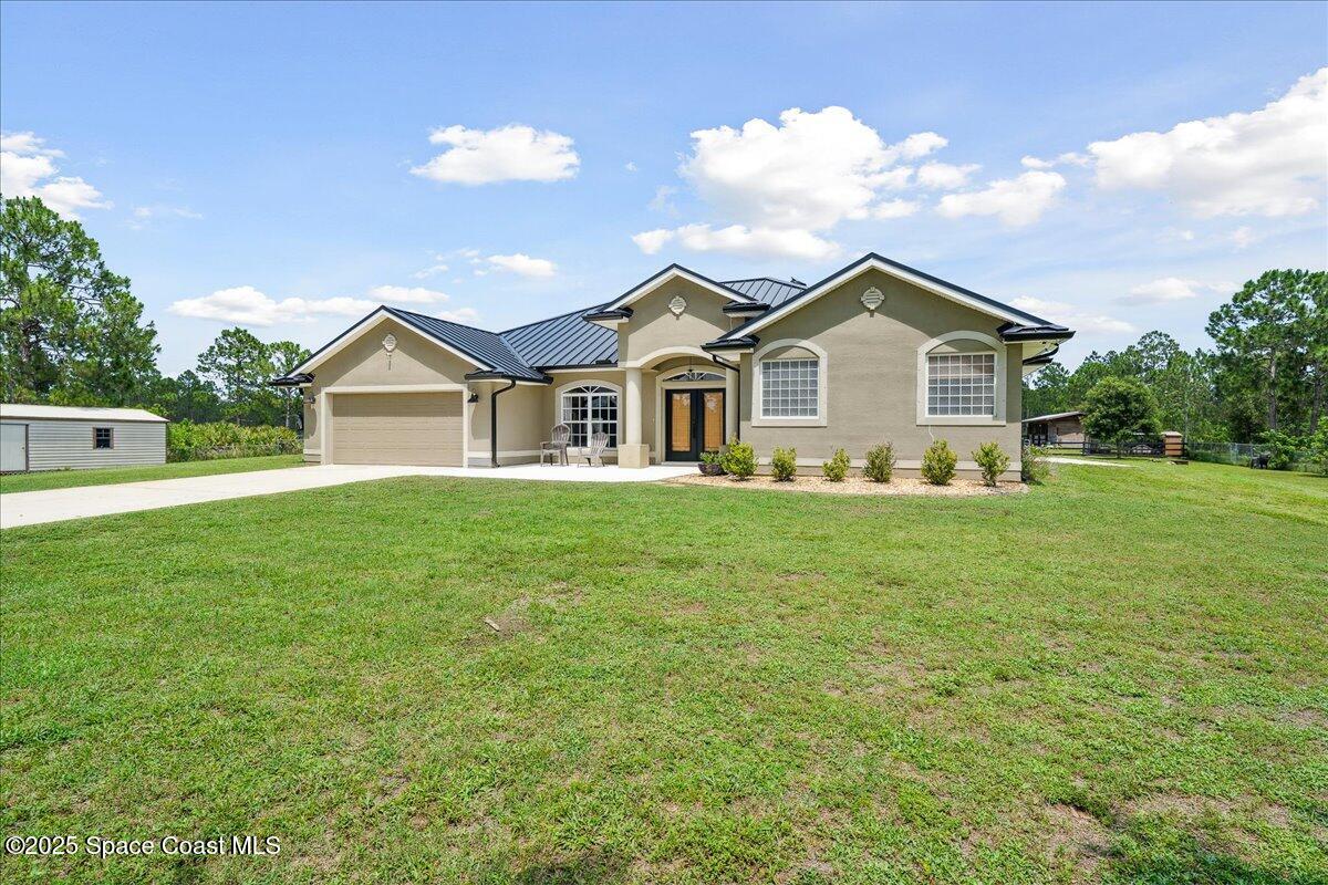 5005 Corey Road Grant Valkaria, FL 32950 - Photo 45 of 47 a front view of a house with a garden