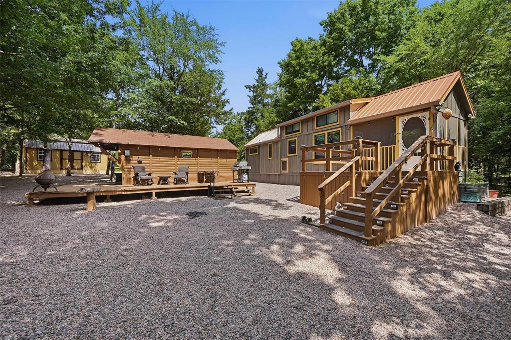 3958 Ranch Road Whitesboro, TX 76273 - Photo 3 of 40 Multi-level property featuring a main structure with a metal roof and an elevated screened porch with wooden stairs
