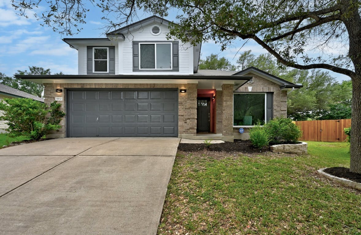 a front view of a house with a yard and garage