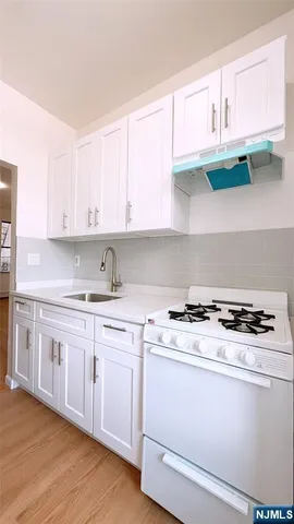 a kitchen with stainless steel appliances granite countertop a sink a stove and cabinets