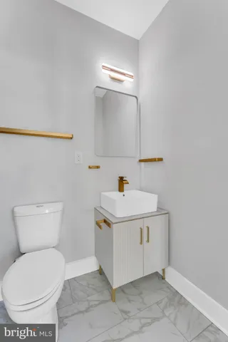 a white toilet sitting next to a bathroom sink