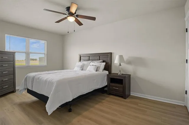 a bedroom with a bed and a ceiling fan