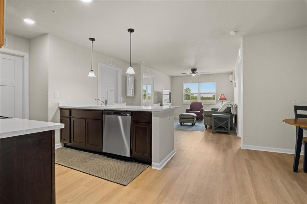 260 Spanish Moss Circle, Unit 101 Sebring, FL 33876 - Photo 3 of 35 a kitchen with stainless steel appliances granite countertop a sink a stove and a wooden floors