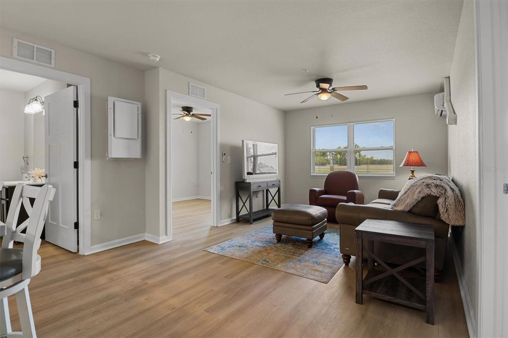 260 Spanish Moss Circle, Unit 101 Sebring, FL 33876 - Photo 7 of 35 a living room with furniture a ceiling fan and a wooden floor