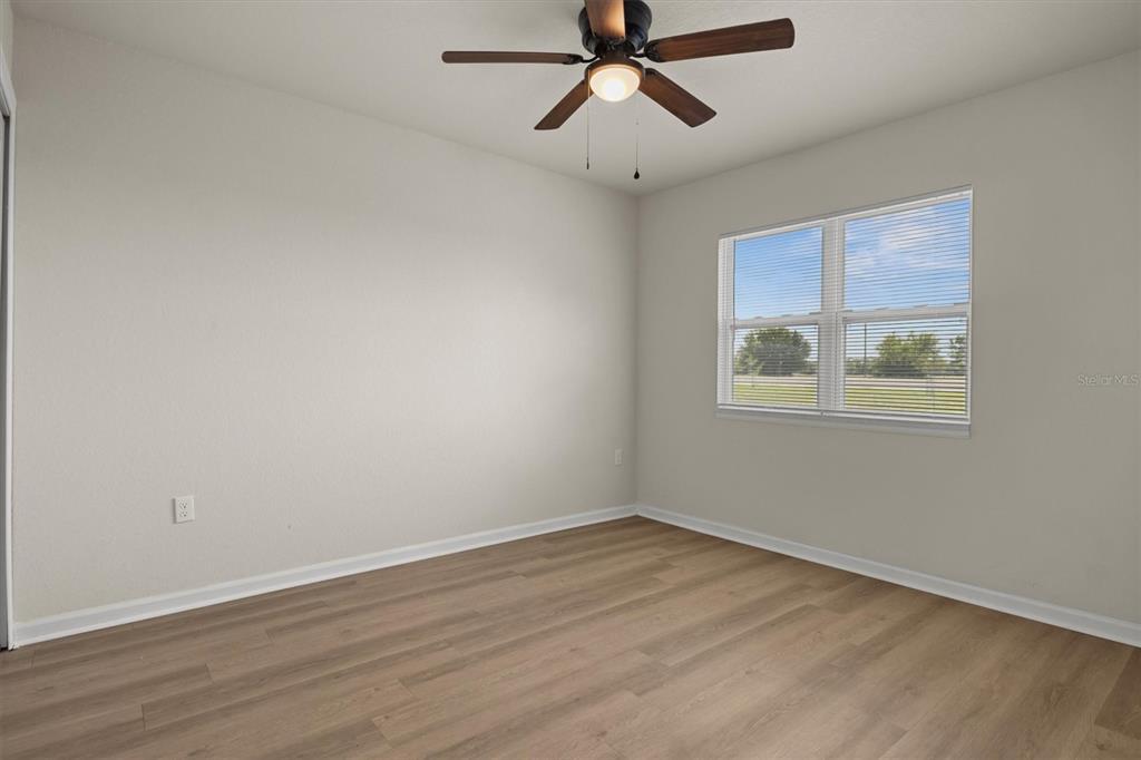 260 Spanish Moss Circle, Unit 101 Sebring, FL 33876 - Photo 8 of 35 a view of empty room with wooden floor and fan