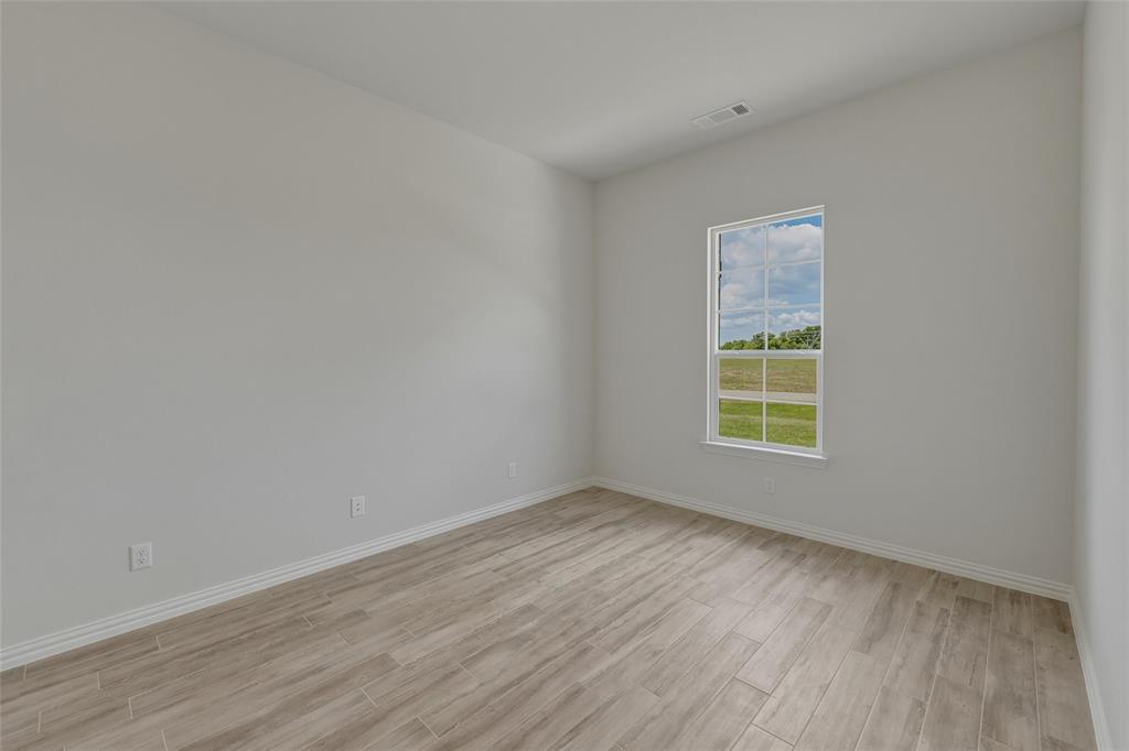 131 Big Sky Road Decatur, TX 76234 - Photo 15 of 23 Light-filled interior featuring neutral wall tones, wood-finish flooring, and a multi-pane window