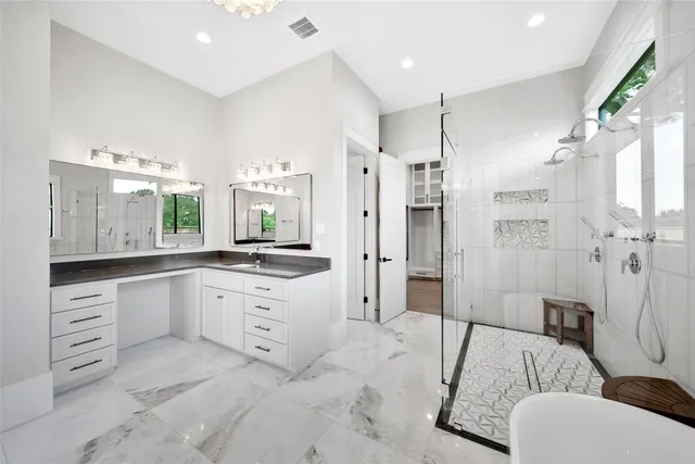 a large white bathroom with a granite countertop sink mirror and a bathtub