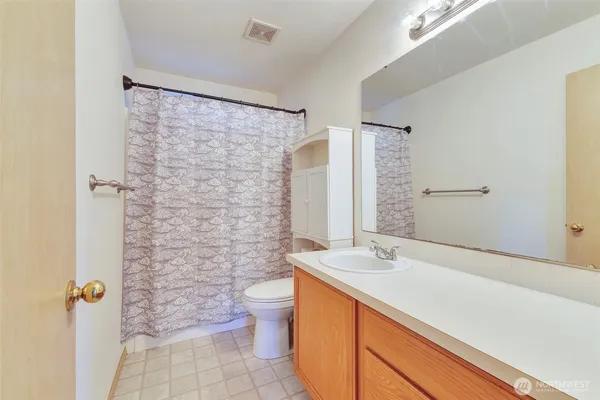 a bathroom with a granite countertop sink a toilet and shower