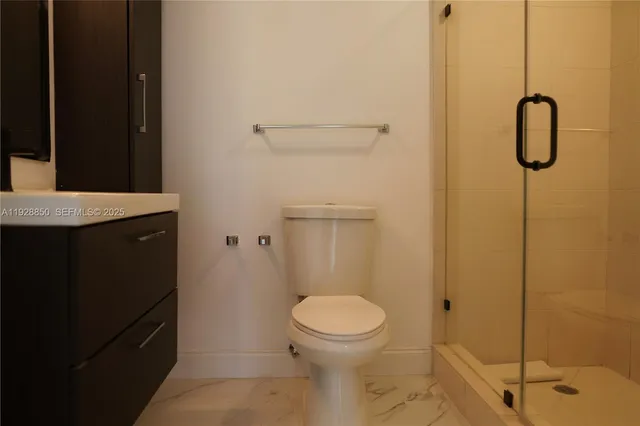 a bathroom with a granite countertop sink toilet and shower