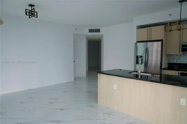a kitchen with granite countertop a sink and a refrigerator