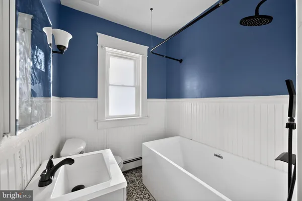 a bathroom with a tub a sink and a window