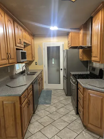 a kitchen with stainless steel appliances granite countertop a sink stove and refrigerator