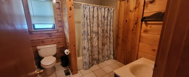 a bathroom with a toilet and a shower curtain