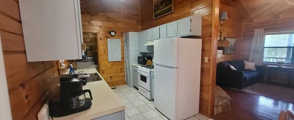 a kitchen with a refrigerator a stove and wooden floor