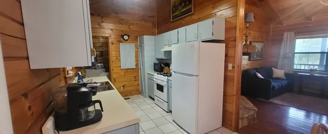 a kitchen with a refrigerator a stove and wooden floor
