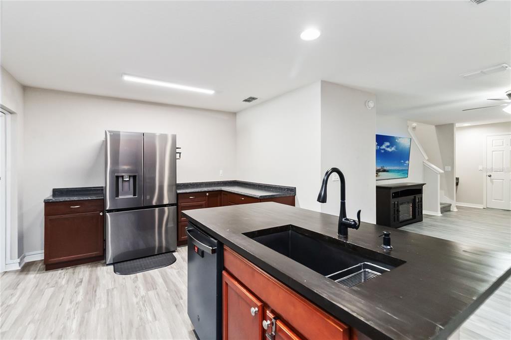 3723 Ricky Lane St. Cloud, FL 34772 - Photo 12 of 36 a kitchen with granite countertop a refrigerator and a stove top oven