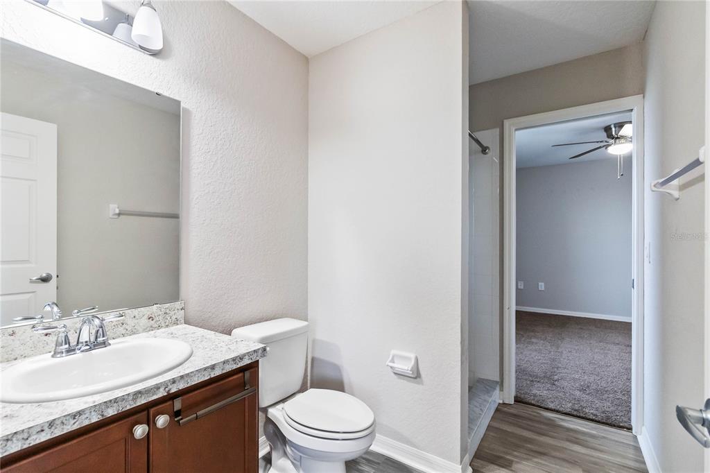 3723 Ricky Lane St. Cloud, FL 34772 - Photo 23 of 36 a bathroom with a granite countertop sink a toilet and a mirror