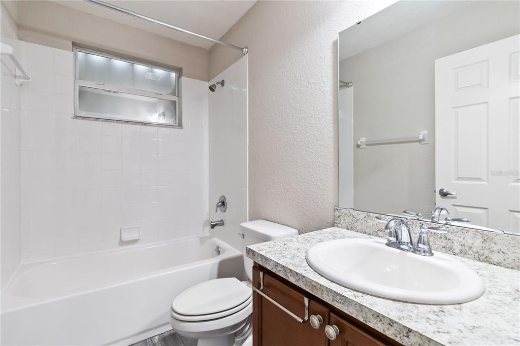 3723 Ricky Lane St. Cloud, FL 34772 - Photo 29 of 36 a bathroom with a granite countertop sink toilet and shower